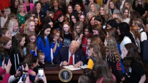 Donald Trump signing the "Keeping Men Out of Women’s Sports" executive order. UPenn Bows to Trump's Transphobic Pressure: Lia Thomas' Records Erased