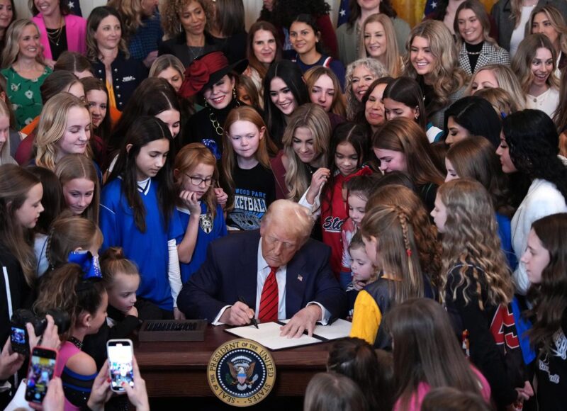 Donald Trump signing the "Keeping Men Out of Women’s Sports" executive order. UPenn Bows to Trump's Transphobic Pressure: Lia Thomas' Records Erased